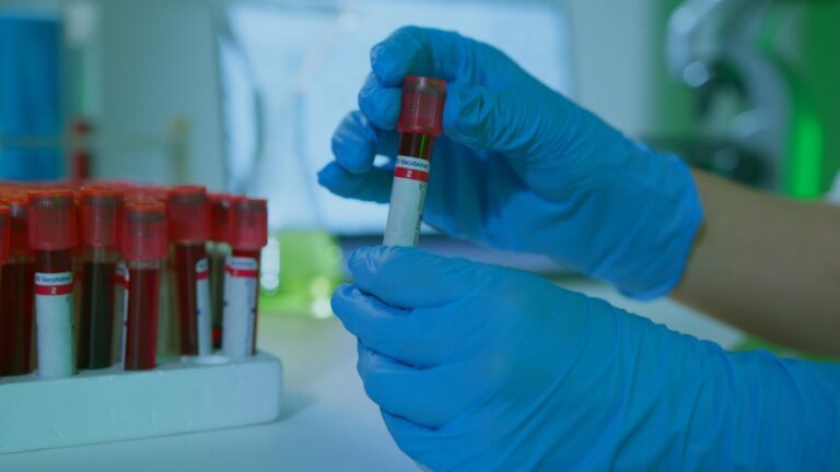 Clear glass laboratory vials on a sterile reflective surface in a cleanroom for scientists looking to Buy Research Peptides UK.