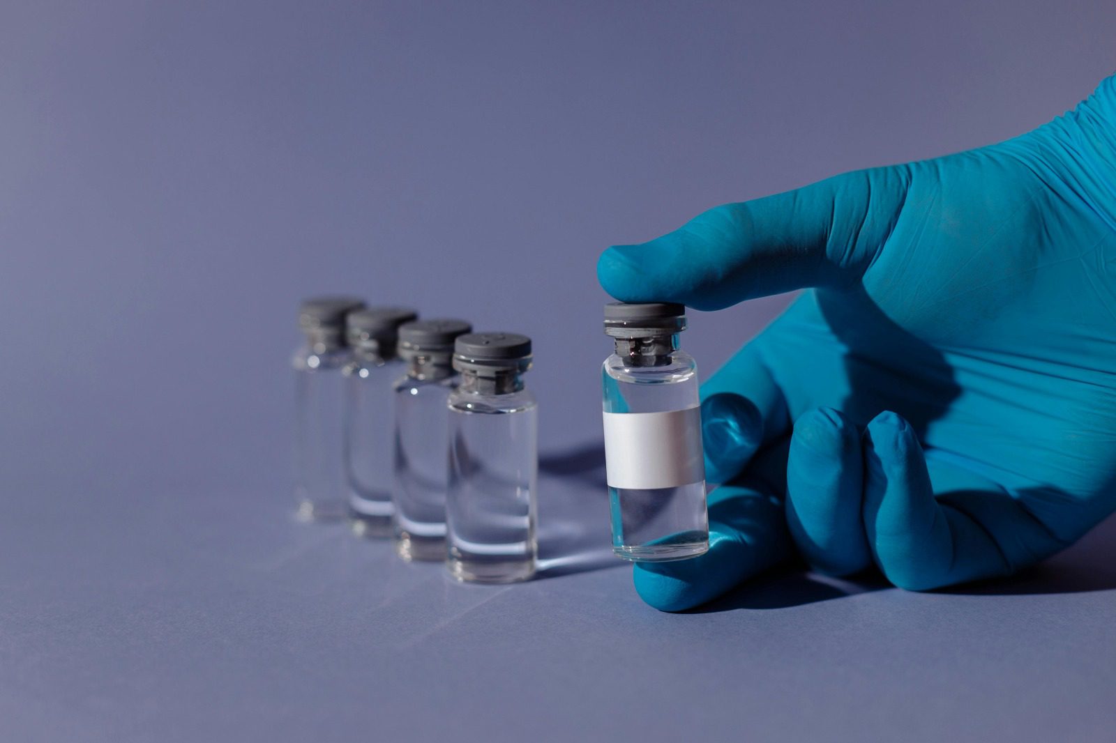 Glazen laboratoriumflacons op een spiegelend steriel oppervlak in een cleanroom voor onderzoekers die hoogwaardige peptiden kopen Nederland overwegen.